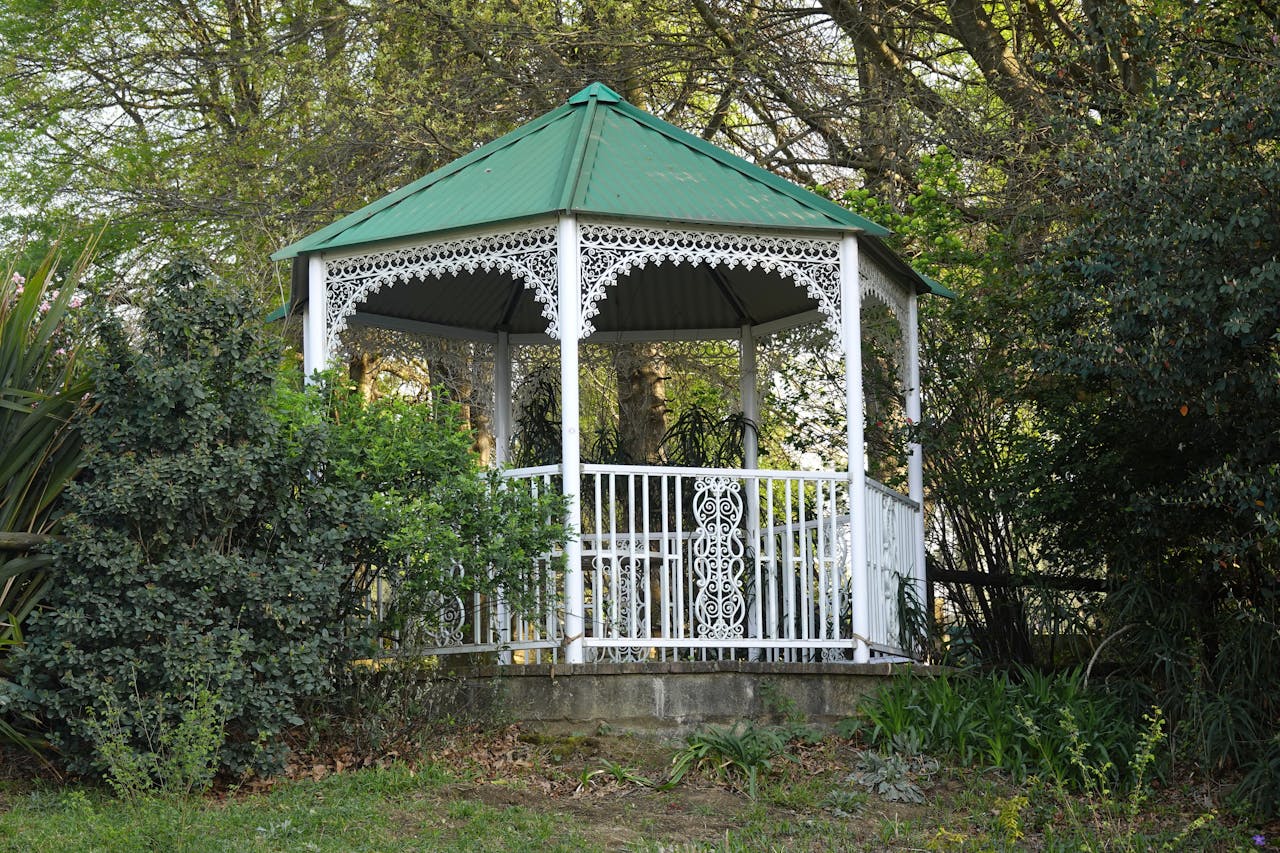 A picturesque white gazebo nestled among lush greenery, perfect for outdoor relaxation.